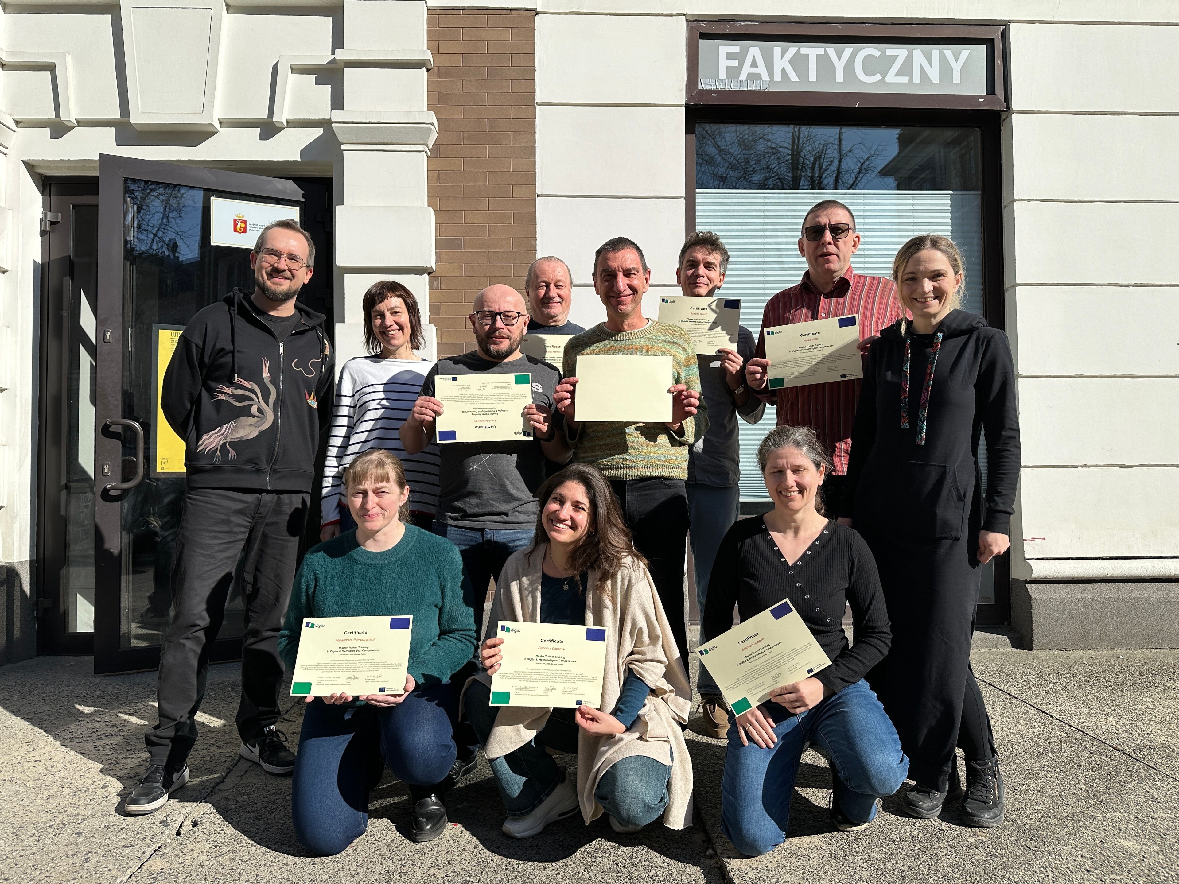 DigLib trainer team posing in Warsaw, holding their certificates of completion after the train-the-trainers workshop.