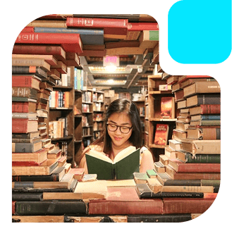 Young woman reading a book, framed by a circular structure made of books in a library.