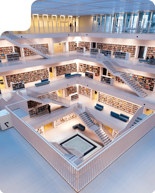 Modern multi-level library interior with open balconies, bookshelves, and people exploring the space.